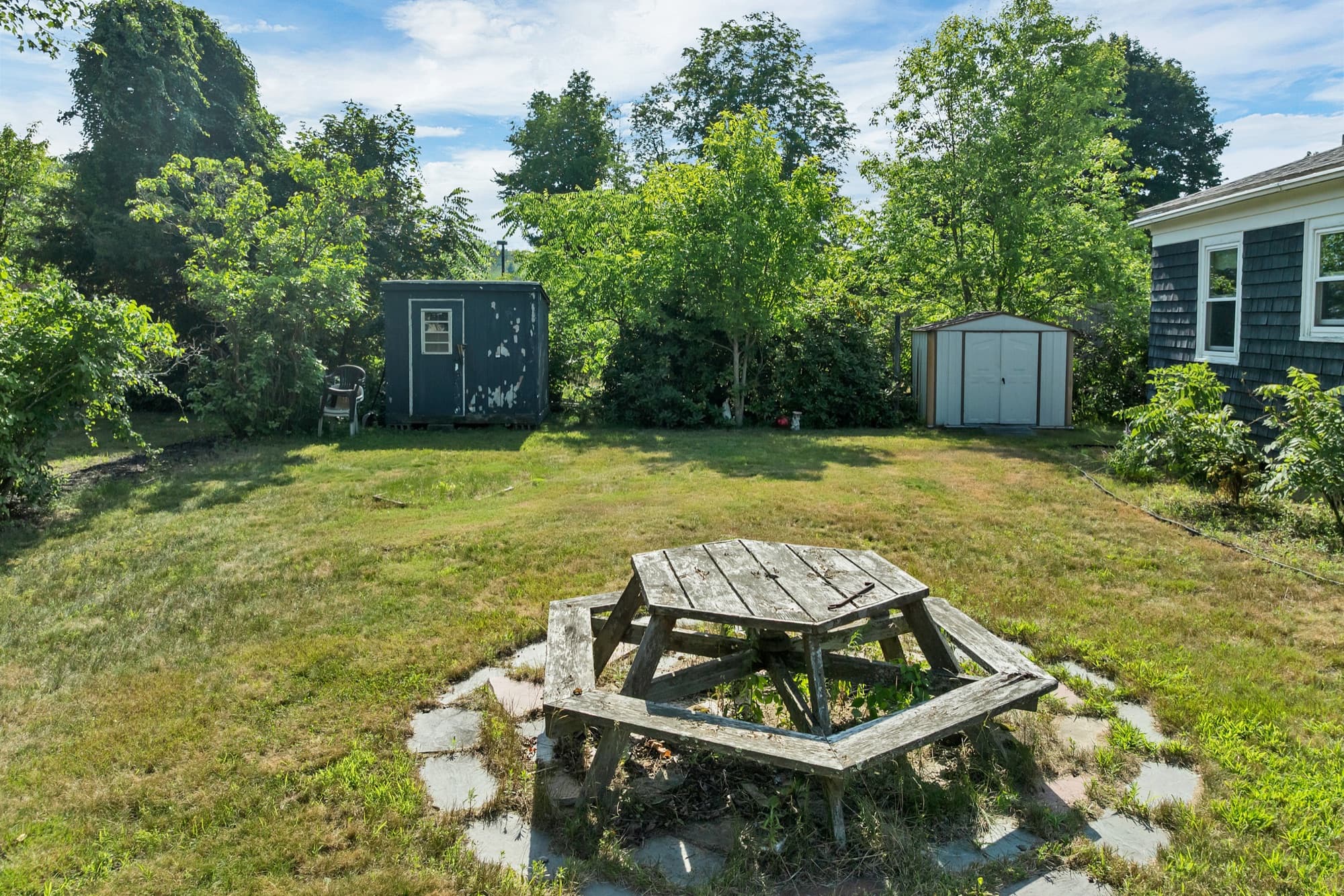Backyard with storage sheds and a picnic table