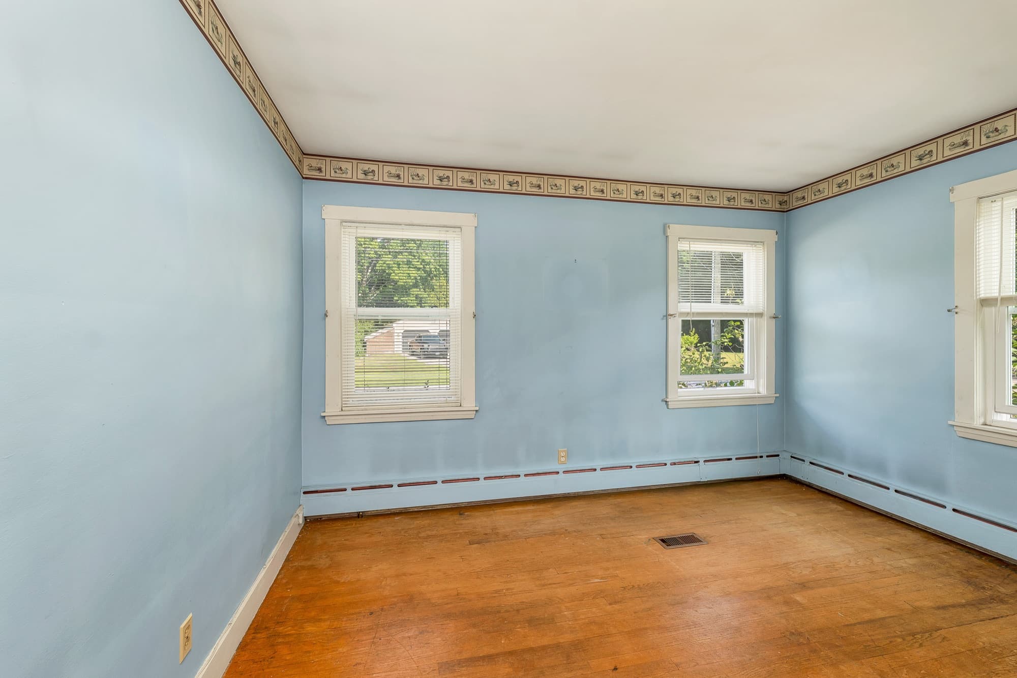 Bedroom with hardwood floors and two windows