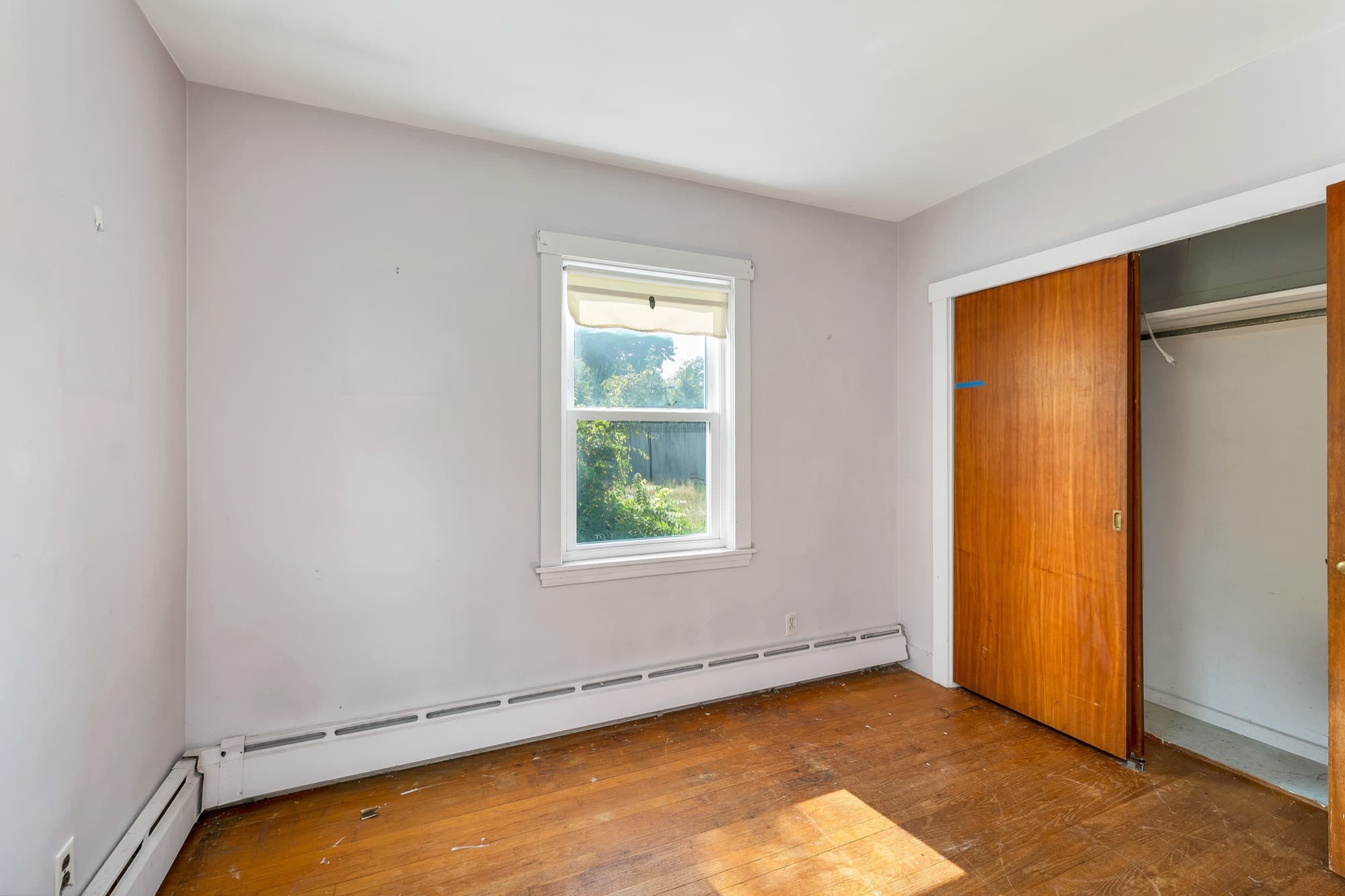 Third bedroom with hardwood floors and a closet