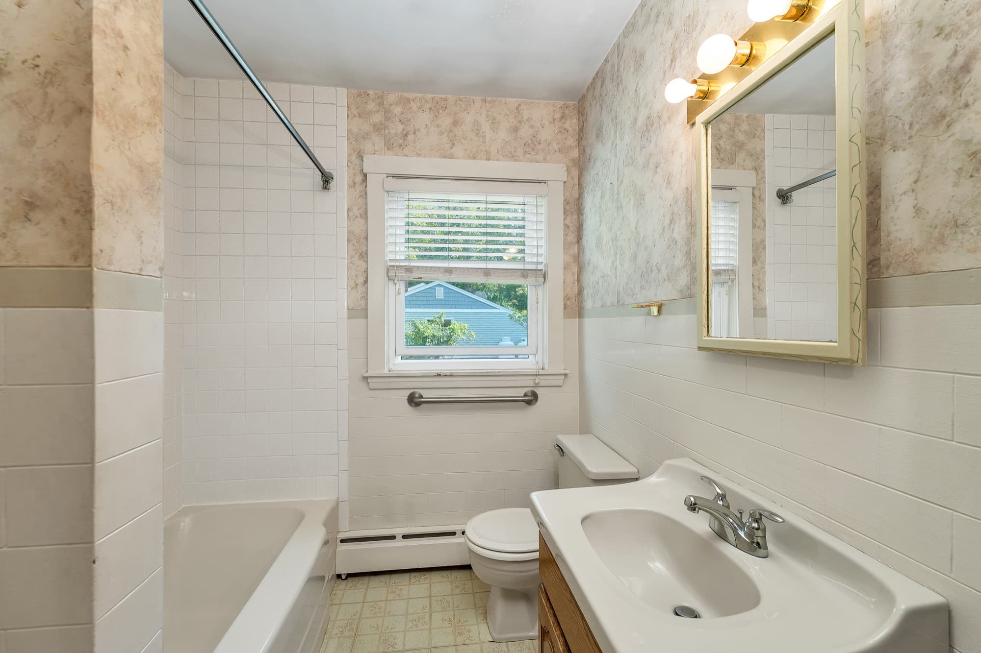 Full bathroom with a tub, vanity, and tiled surround