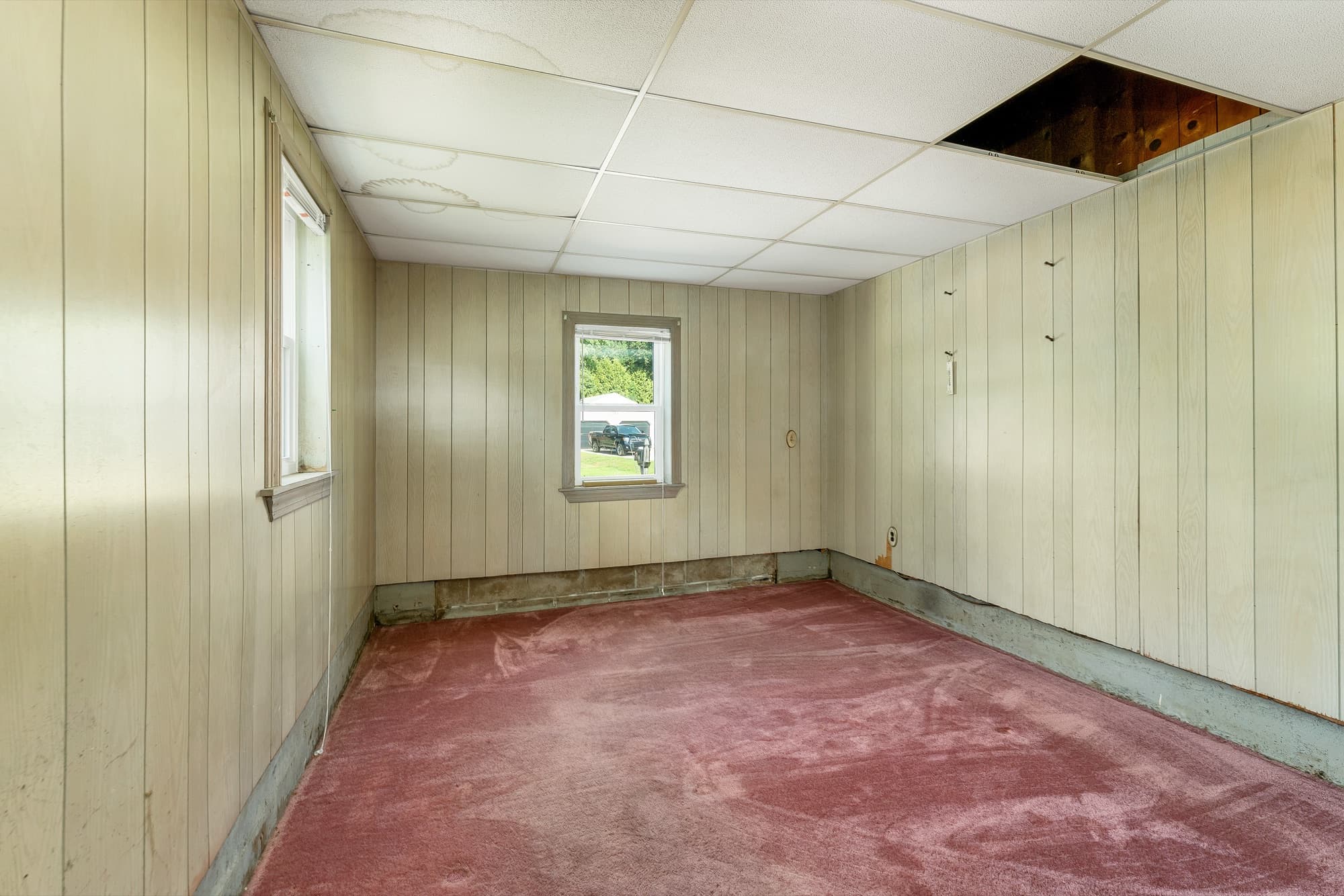 Basement room with a drop ceiling, awaiting renovation
