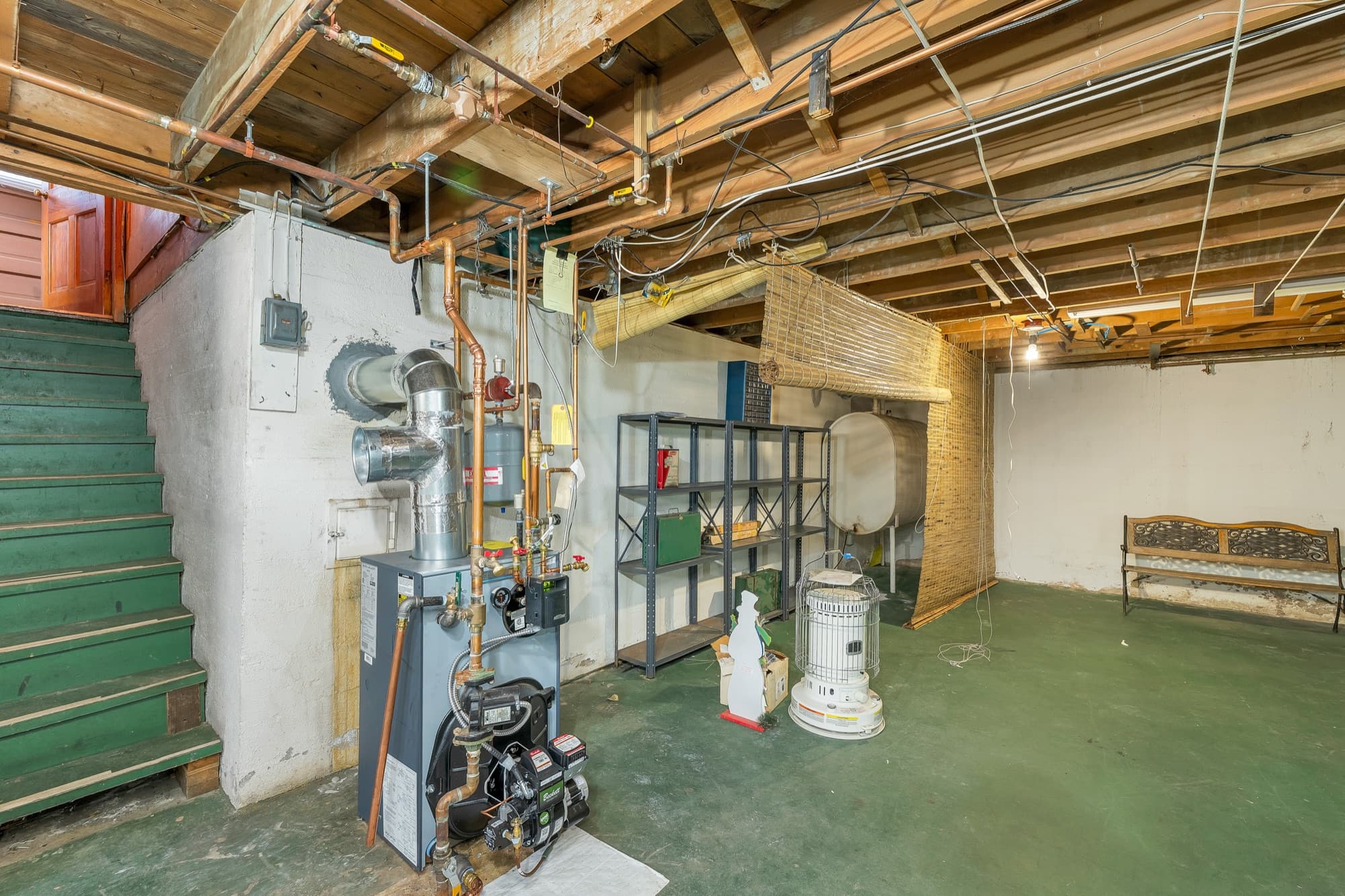 Unfinished basement with the heating system and interior stairs